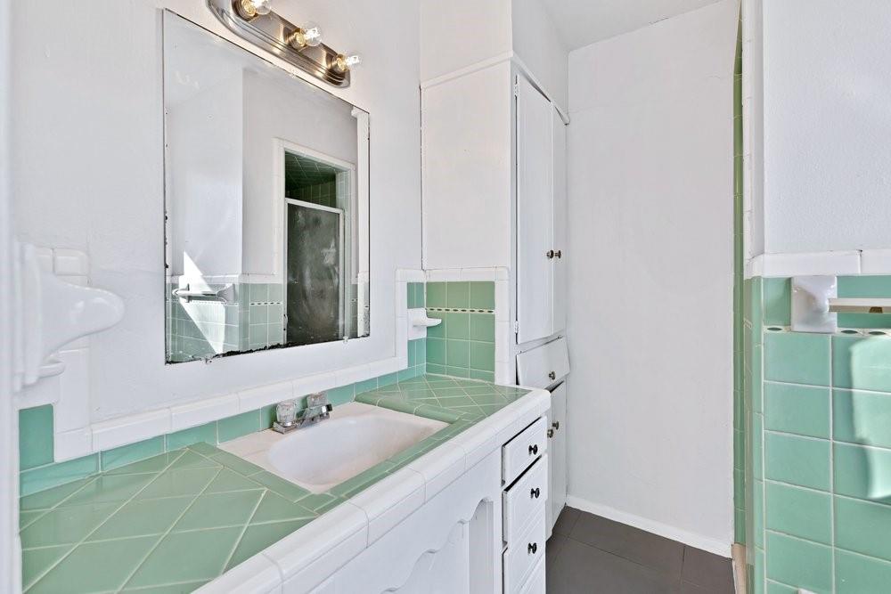 314 Fulton Street Denton, TX 76201 - Photo 16 of 29 a bathroom with a granite countertop sink and a mirror