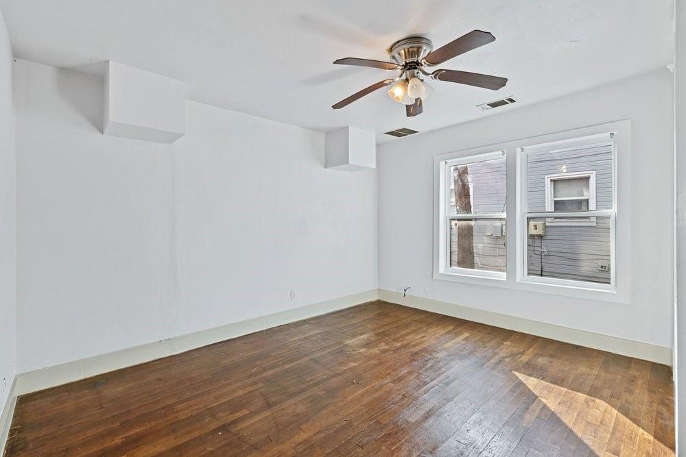 314 Fulton Street Denton, TX 76201 - Photo 17 of 29 a view of an empty room with wooden floor and a window