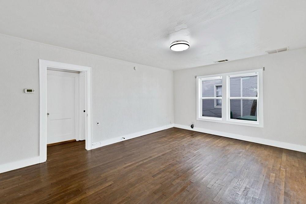 314 Fulton Street Denton, TX 76201 - Photo 3 of 29 a view of an empty room with wooden floor and a window