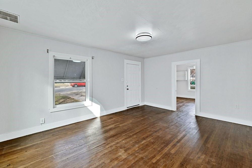 314 Fulton Street Denton, TX 76201 - Photo 4 of 29 an empty room with wooden floor and mirror