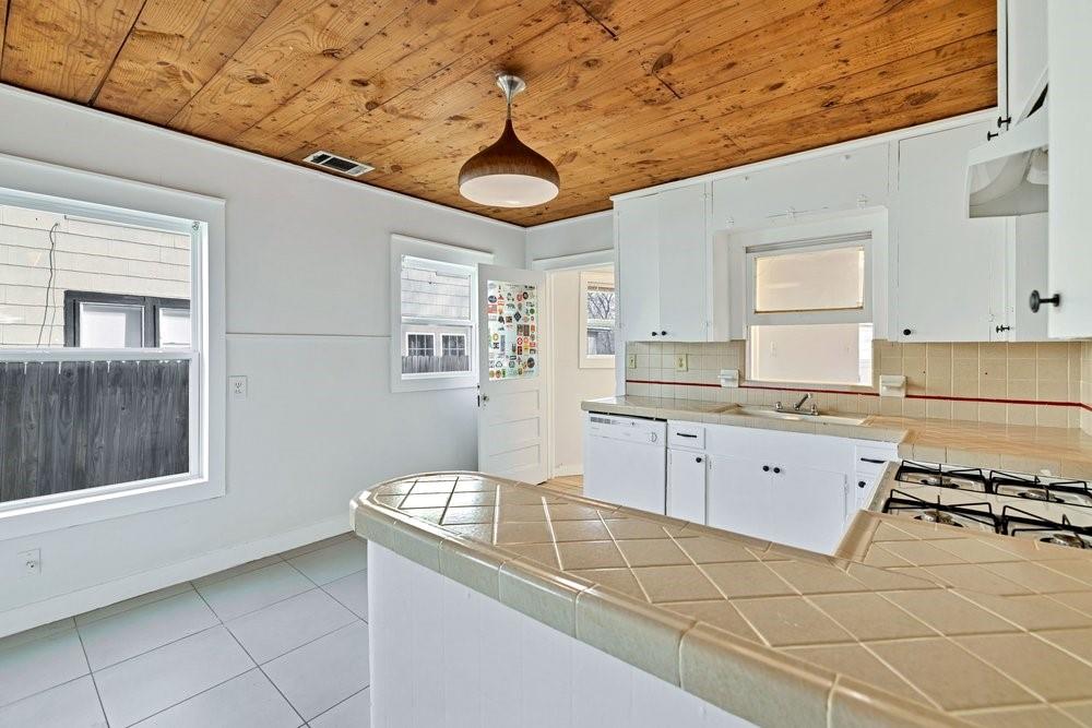 314 Fulton Street Denton, TX 76201 - Photo 9 of 29 a kitchen with stainless steel appliances granite countertop a sink and cabinets with wooden floor