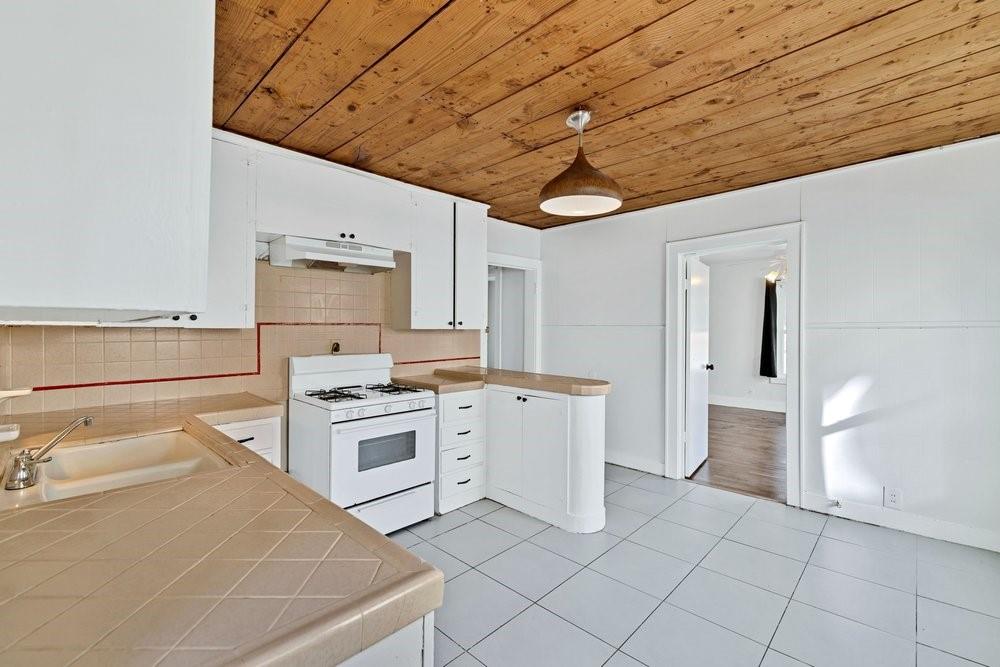 314 Fulton Street Denton, TX 76201 - Photo 10 of 29 a kitchen with a stove a sink and a refrigerator