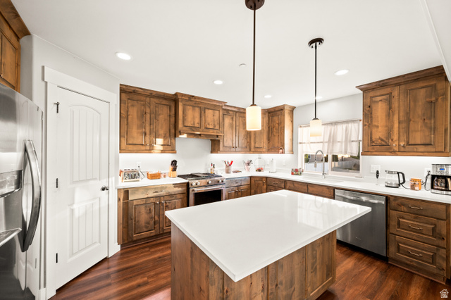 1145 North Christley Lane, Unit 48 Elk Ridge, UT 84651 - Photo 4 of 38 Spacious kitchen featuring a large central island with a white solid surface countertop, wood-finish flooring, full-height wood cabinetry, stainless steel appliances, and recessed lighting