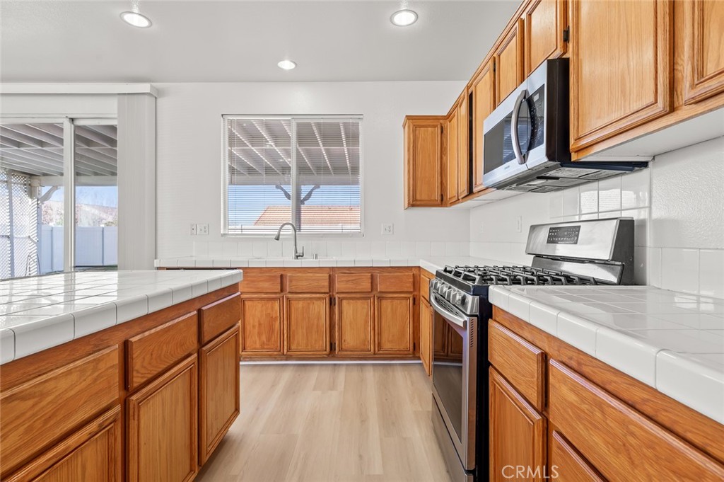 6323 Scalea Court Palmdale, CA 93552 - Photo 20 of 58 a kitchen with stainless steel appliances granite countertop a sink stove and cabinets