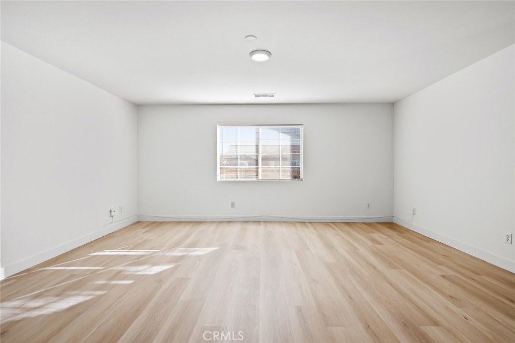 6323 Scalea Court Palmdale, CA 93552 - Photo 28 of 58 an empty room with wooden floor and windows
