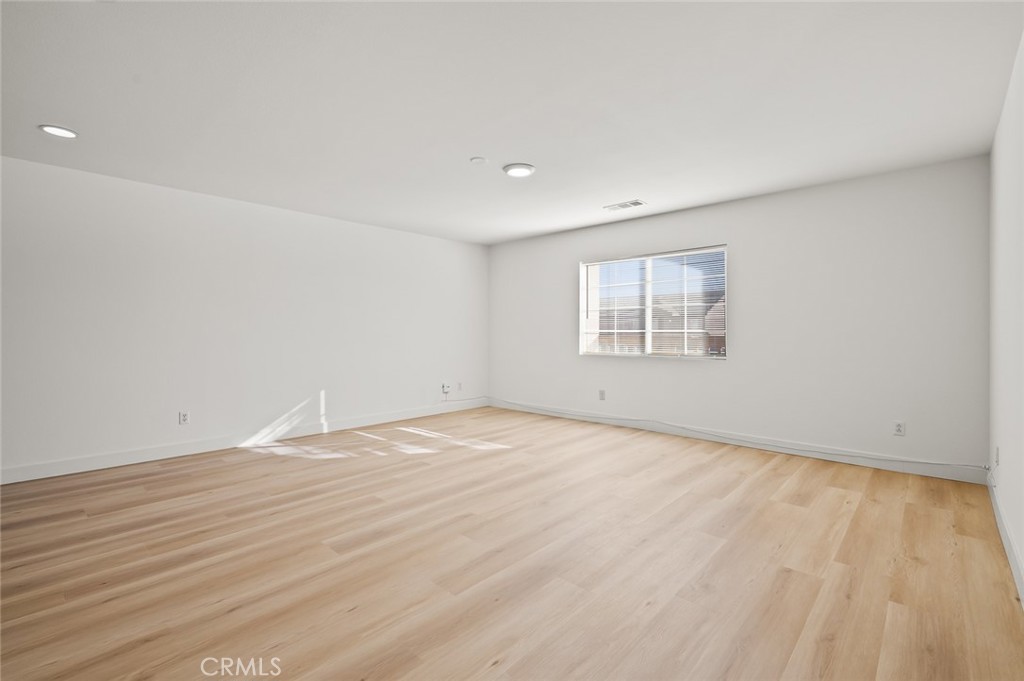 6323 Scalea Court Palmdale, CA 93552 - Photo 31 of 58 a view of an empty room with wooden floor and a window