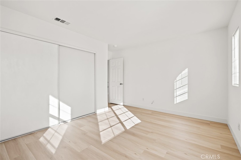 6323 Scalea Court Palmdale, CA 93552 - Photo 36 of 58 an empty room with wooden floor and windows