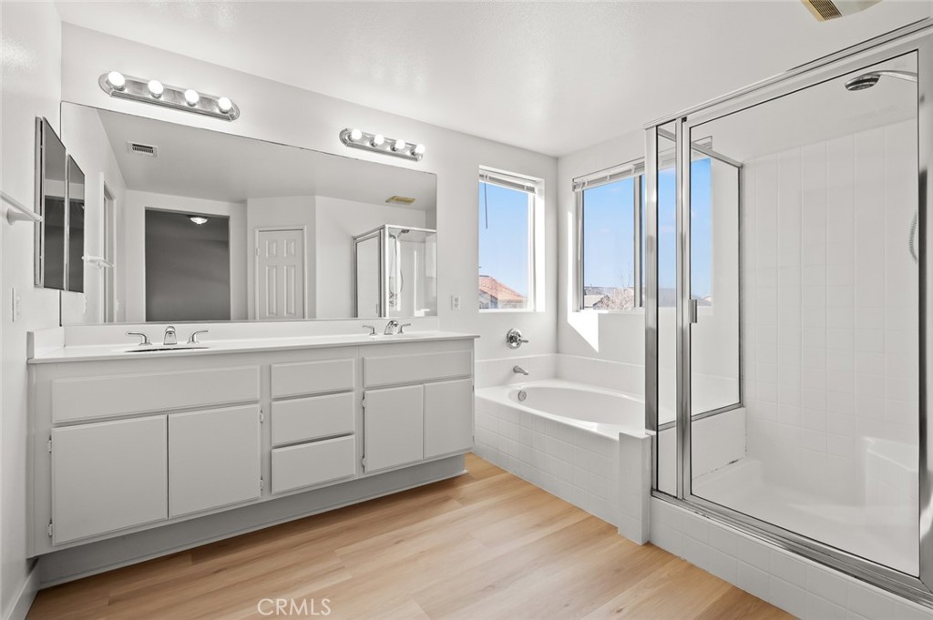 6323 Scalea Court Palmdale, CA 93552 - Photo 45 of 58 a spacious bathroom with a shower a sink and a mirror