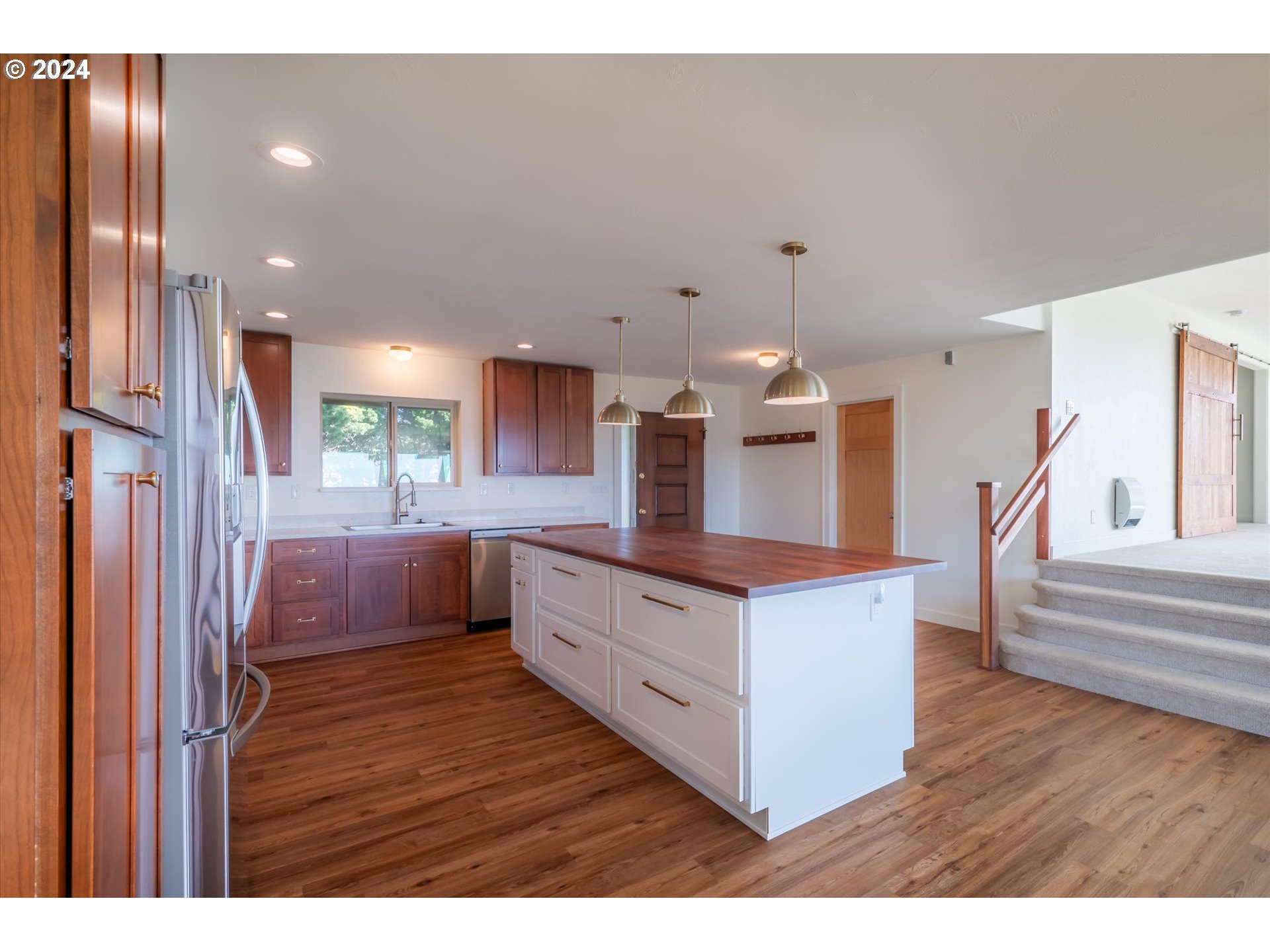 1190 Beach Loop Road Bandon, OR 97411 - Photo 12 of 39 a kitchen with stainless steel appliances kitchen island wooden floors and white walls