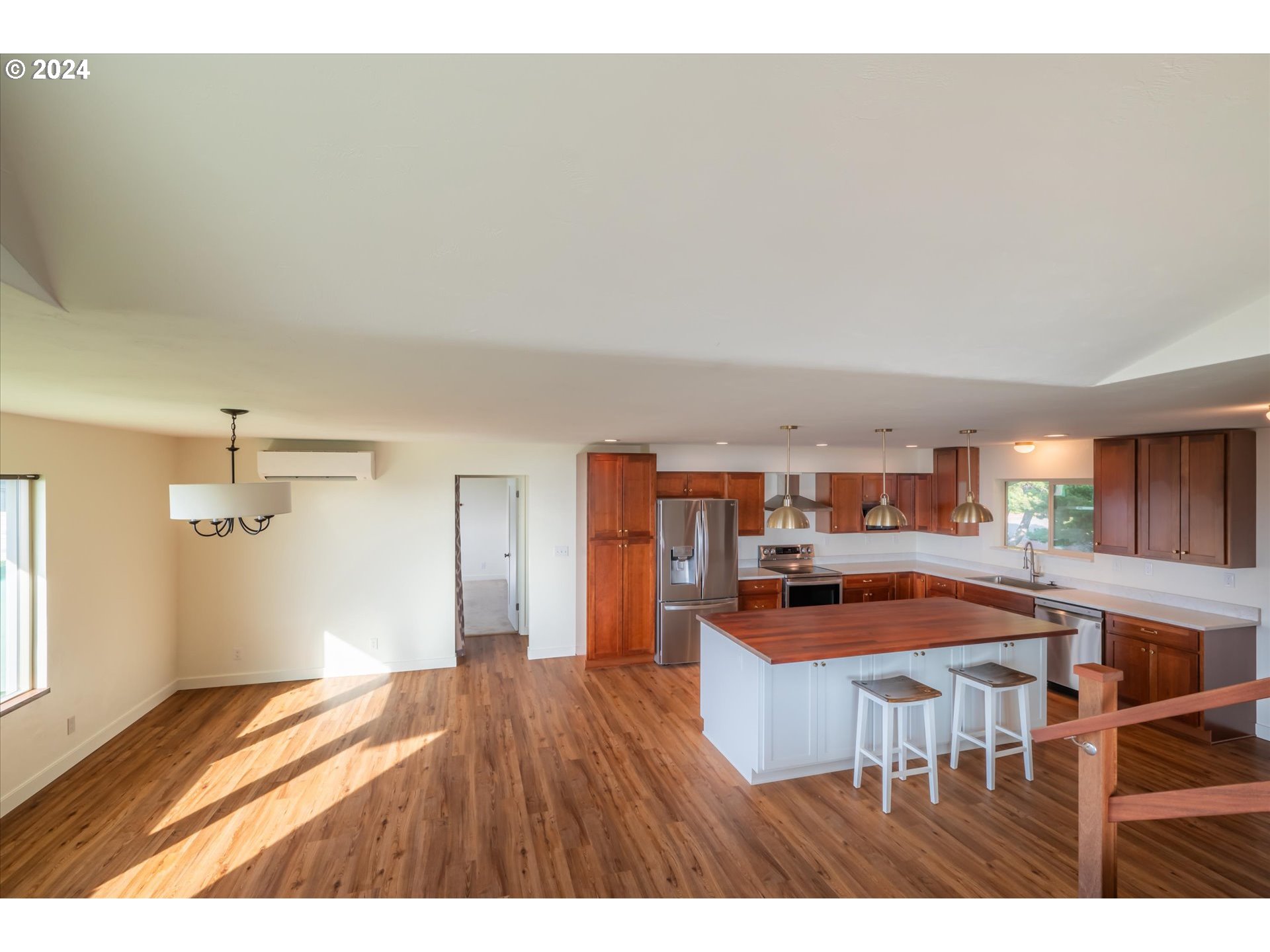 1190 Beach Loop Road Bandon, OR 97411 - Photo 13 of 39 a kitchen with stainless steel appliances granite countertop a refrigerator a sink dishwasher a stove and a dining table with wooden floor