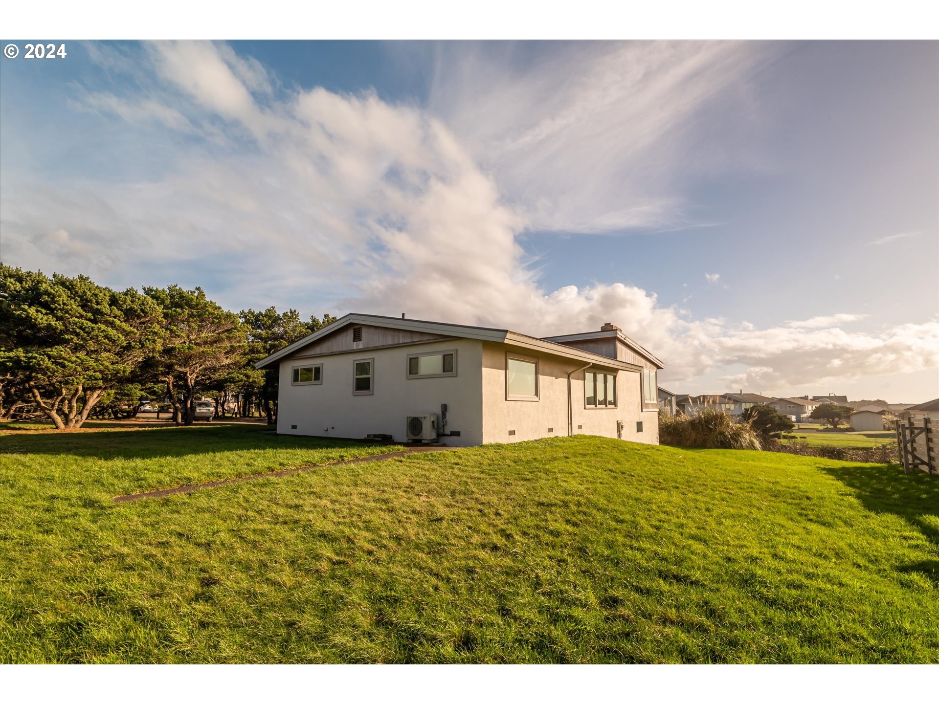 1190 Beach Loop Road Bandon, OR 97411 - Photo 36 of 39 a view of a big house with a big yard and large trees