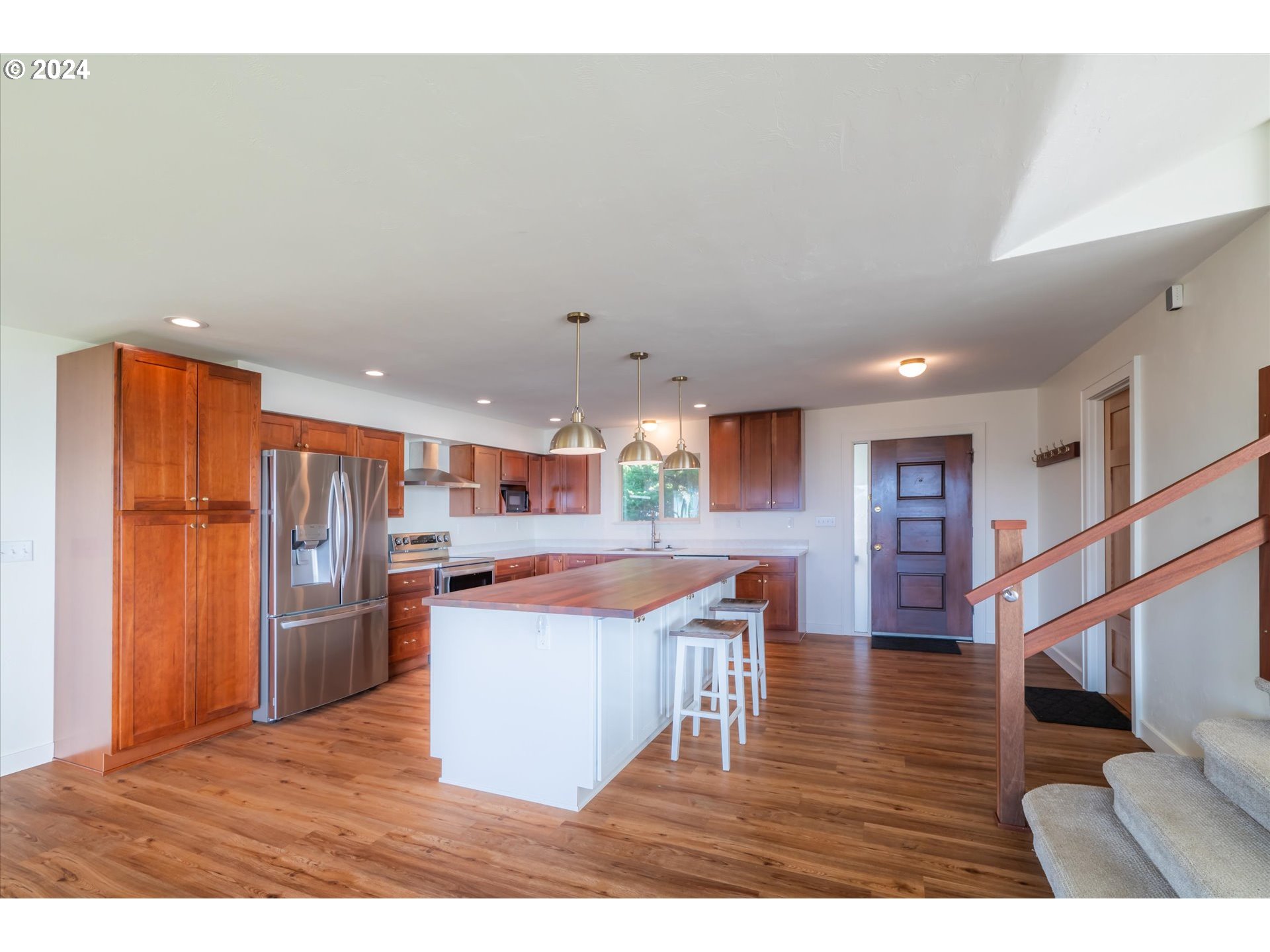 1190 Beach Loop Road Bandon, OR 97411 - Photo 8 of 39 a kitchen with stainless steel appliances granite countertop a refrigerator a sink dishwasher a stove and a dining table with wooden floor