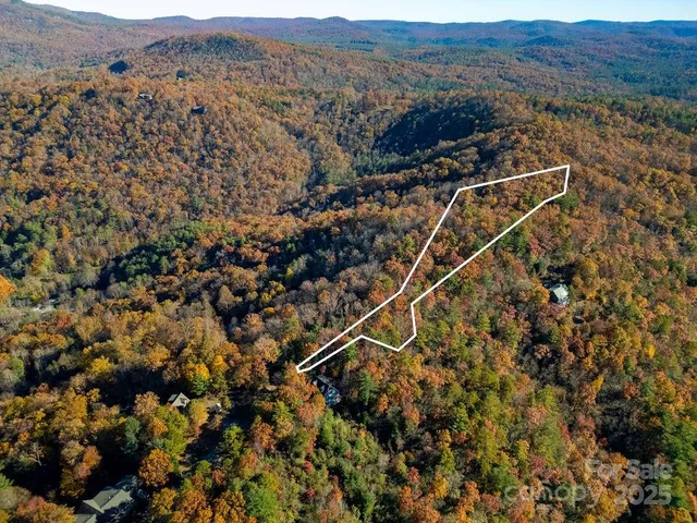 an aerial view of house with yard and mountain view in back