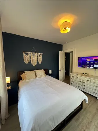 a bedroom with a bed and painting on the wall