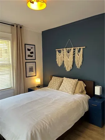 a bedroom with a bed and a painting on the wall