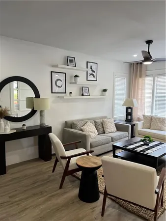 a living room with furniture and a wooden floor