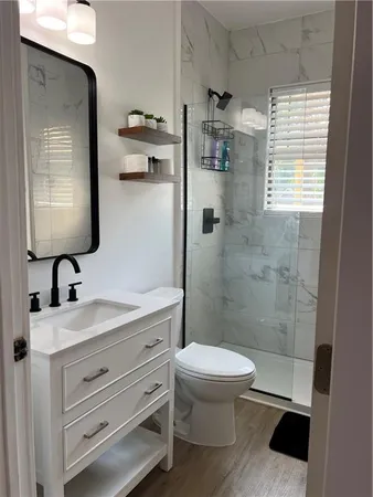 a bathroom with a sink a toilet and shower