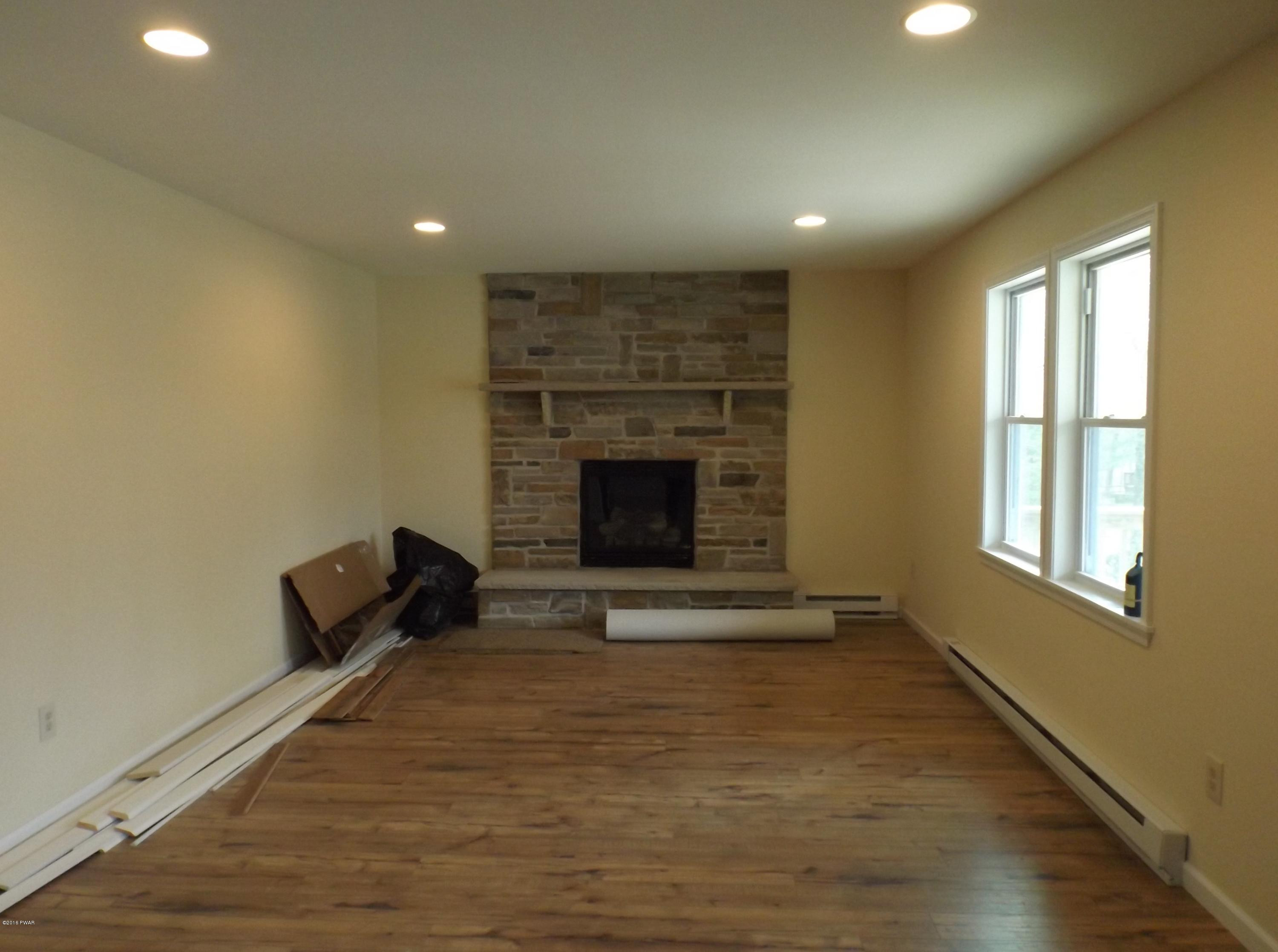 109 Keystone Court Dingmans Ferry, PA 18328 - Photo 4 of 18 an empty room with windows and fireplace