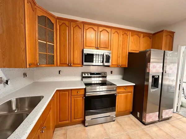a kitchen with stainless steel appliances granite countertop a refrigerator stove and sink