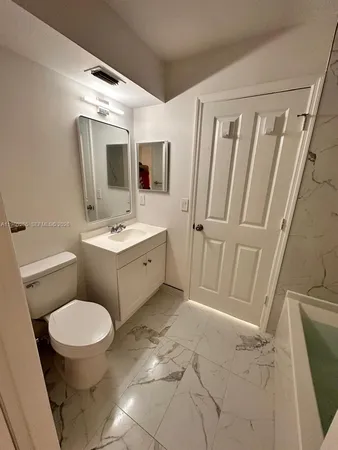 a bathroom with a sink a toilet a mirror a vanity and shower