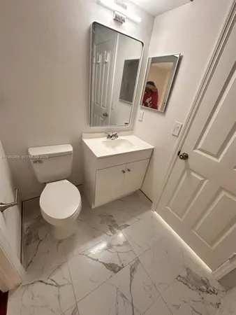 a bathroom with a toilet sink and mirror