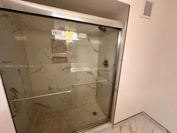 a bathroom with a glass shower door
