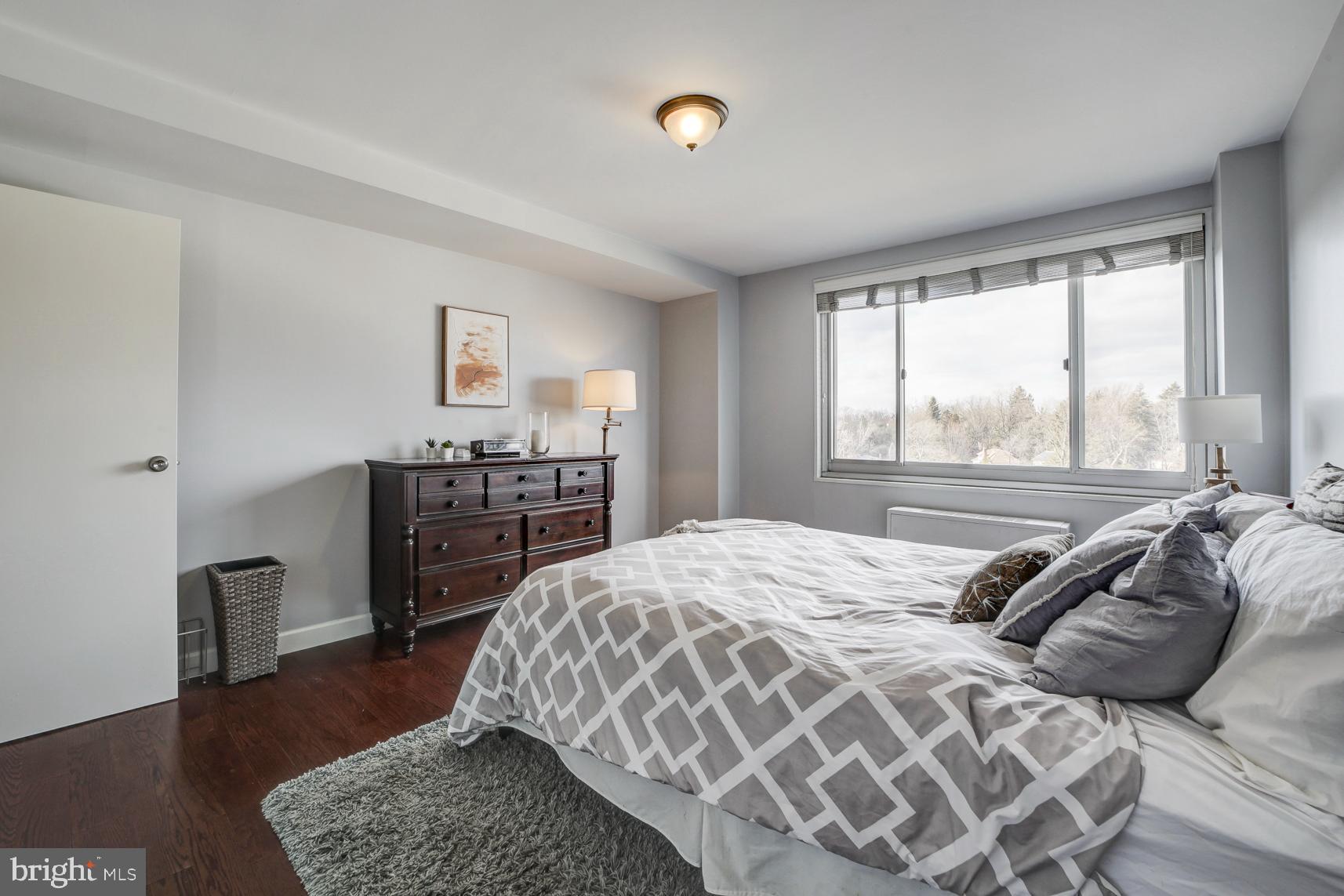 1900 Lyttonsville Road, Unit 1105 Silver Spring, MD 20910 - Photo 12 of 17 a bedroom with a bed and wooden floor