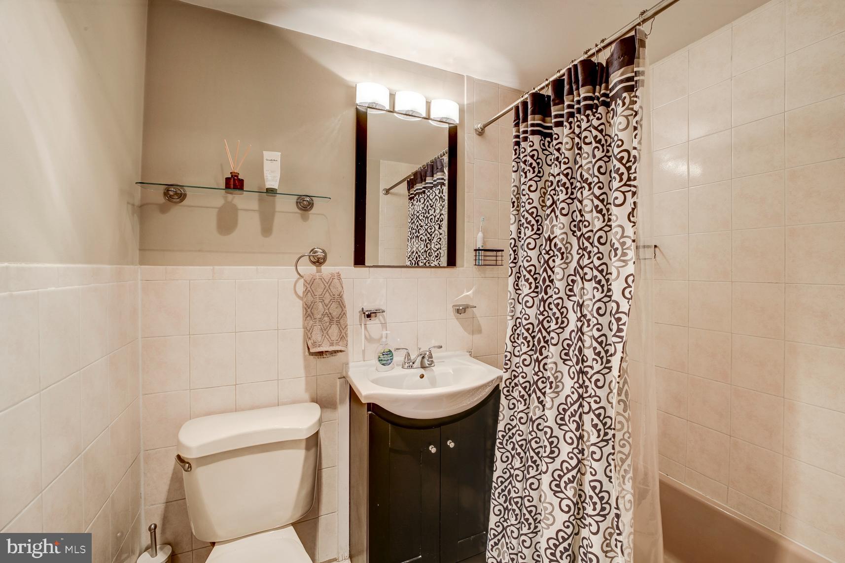 1900 Lyttonsville Road, Unit 1105 Silver Spring, MD 20910 - Photo 13 of 17 a bathroom with a sink a toilet and shower