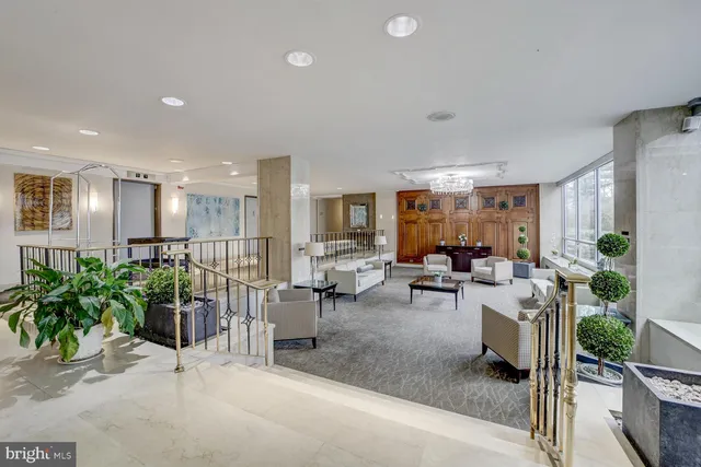 a living room with lots of furniture and a potted plant