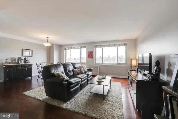 a living room with furniture wooden floor and a window