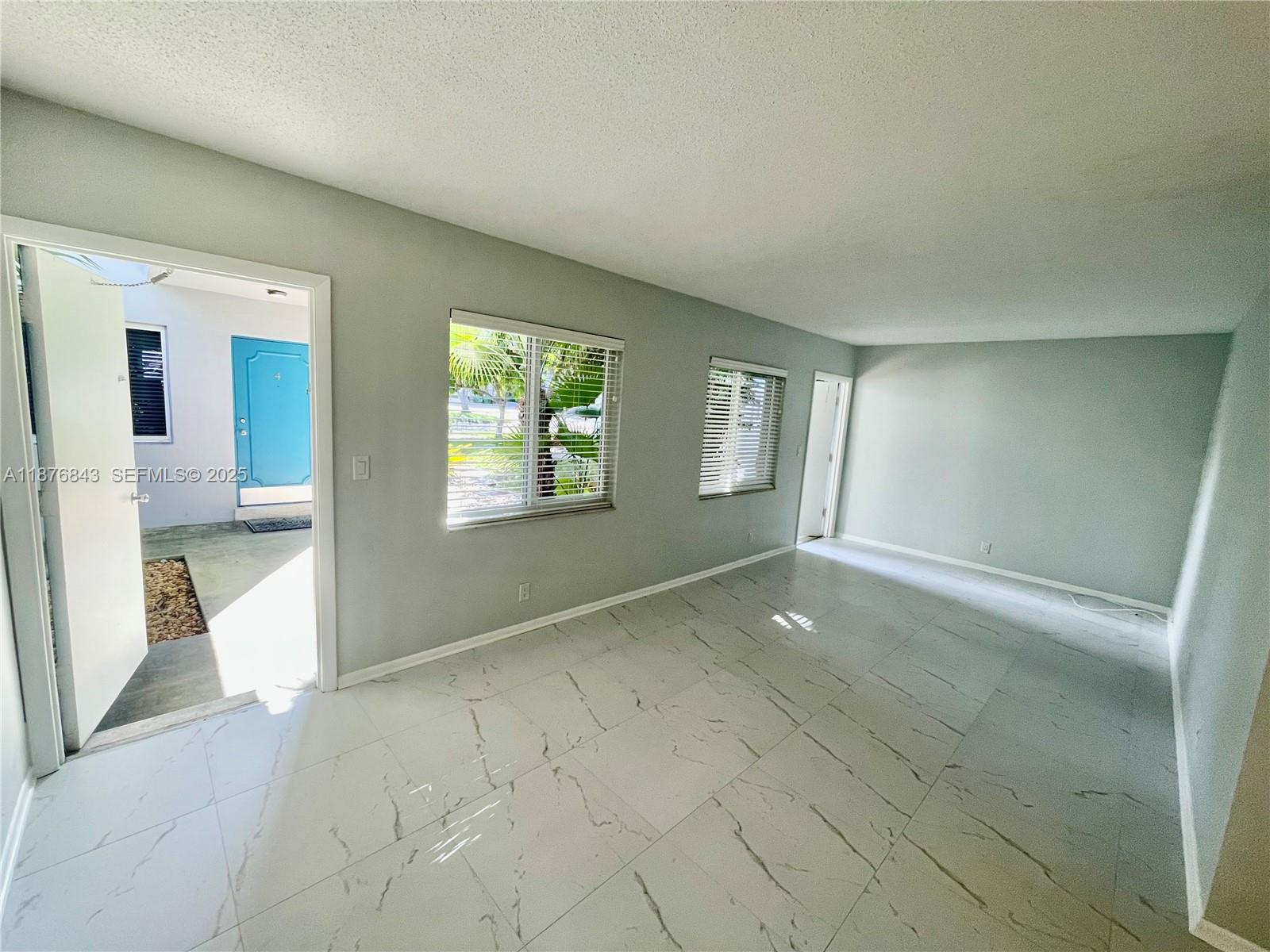 2616 Northeast 14th Avenue, Unit 2 Wilton Manors, FL 33334 - Photo 15 of 16 an empty room with windows and entrance