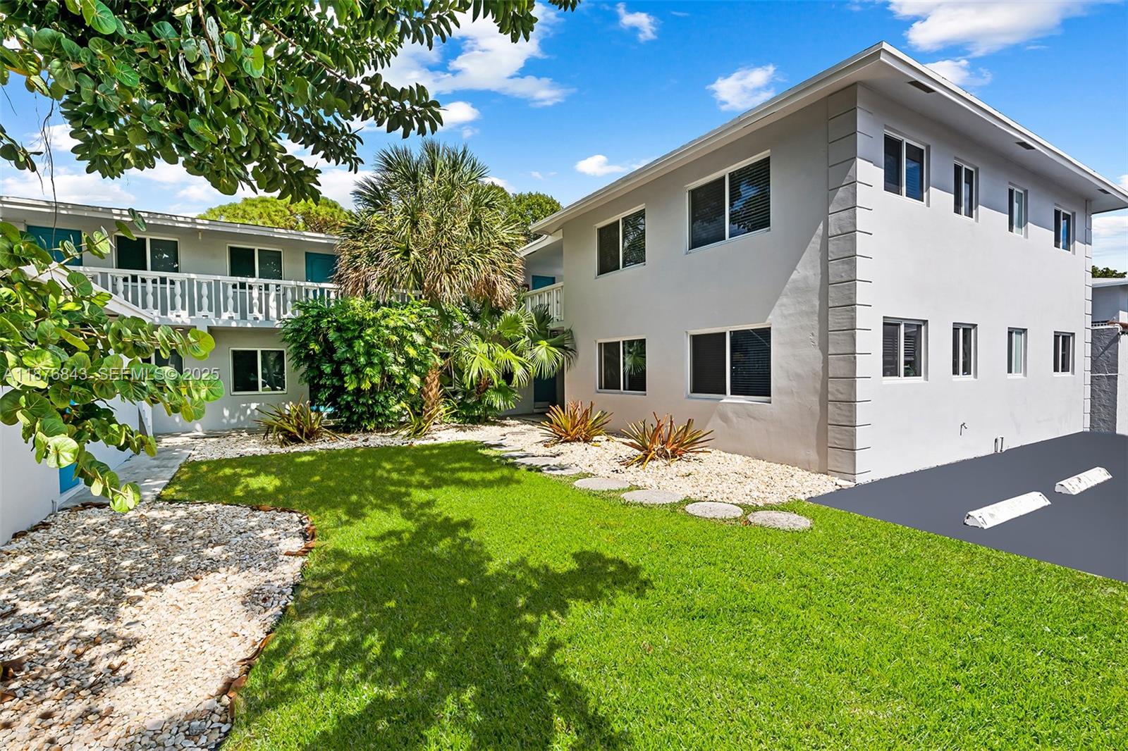 2616 Northeast 14th Avenue, Unit 2 Wilton Manors, FL 33334 - Photo 4 of 16 a front view of a house with a yard and porch