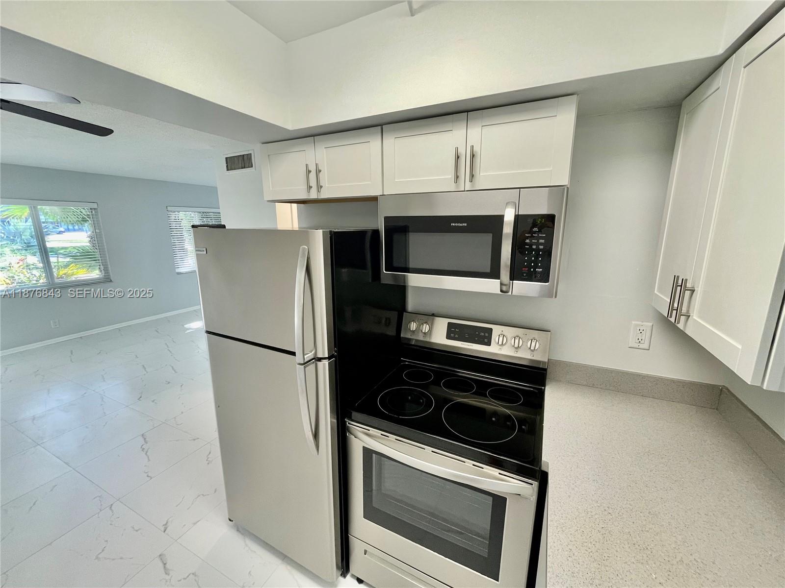 2616 Northeast 14th Avenue, Unit 2 Wilton Manors, FL 33334 - Photo 7 of 16 a kitchen with stainless steel appliances a refrigerator stove and microwave