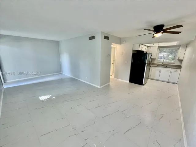 a view of a kitchen with a sink and a refrigerator