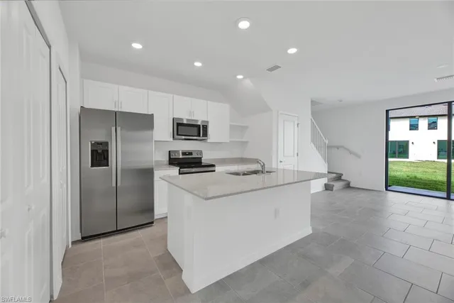 a kitchen that has a sink and stainless steel appliances