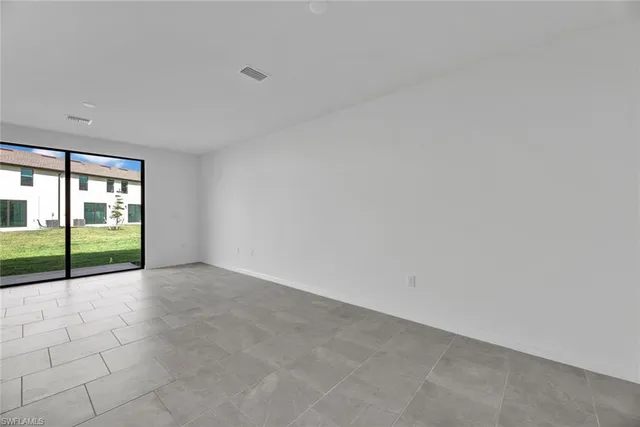 a view of an empty room with a floor to ceiling window and a sink