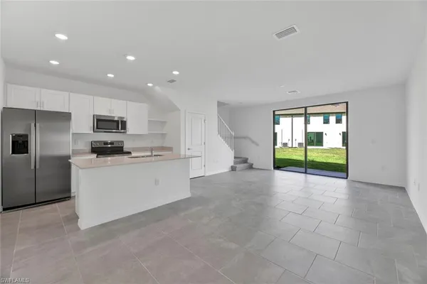 a view of a kitchen with a sink and an entryway
