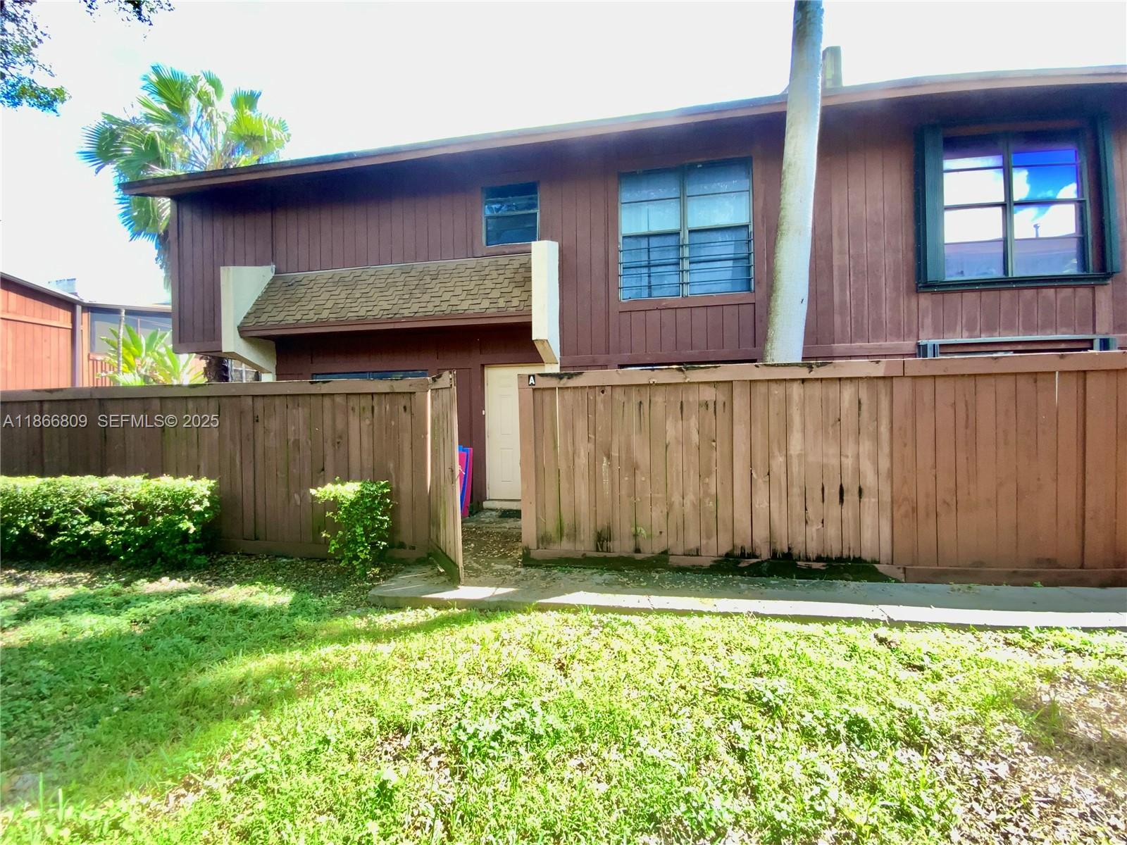 a view of backyard with potted plants and a wooden fence