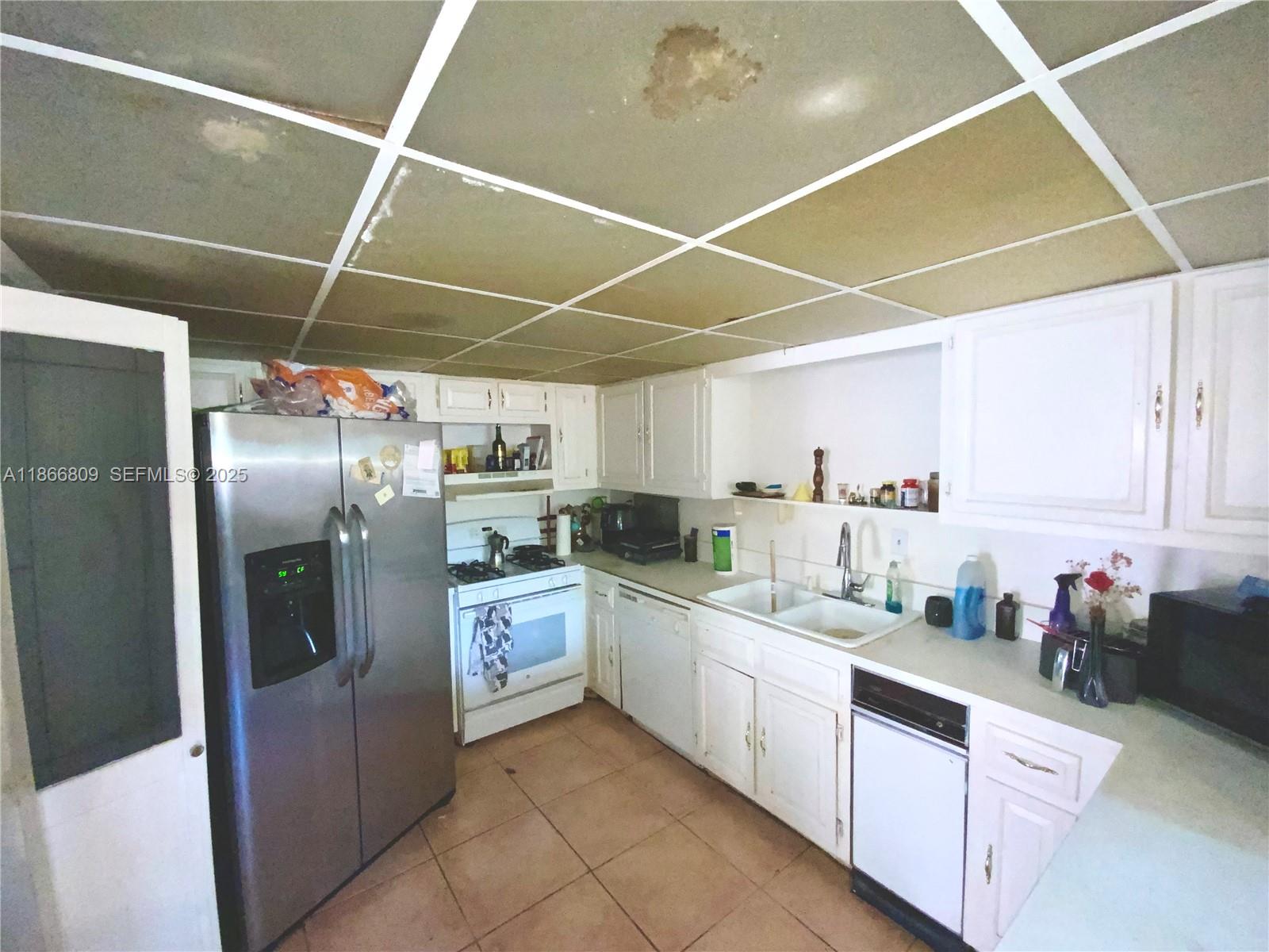 7024 Southwest 114th Place, Unit A52 Miami, FL 33173 - Photo 2 of 41 a kitchen with white cabinets and white appliances