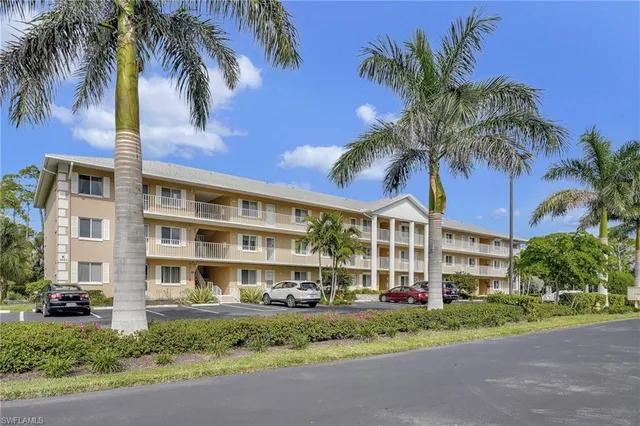 a view of a building with a yard and palm trees