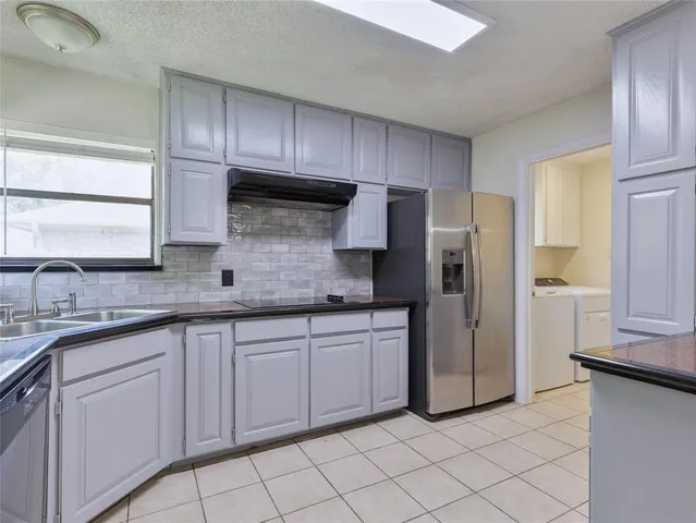 a kitchen with stainless steel appliances granite countertop a refrigerator and a sink