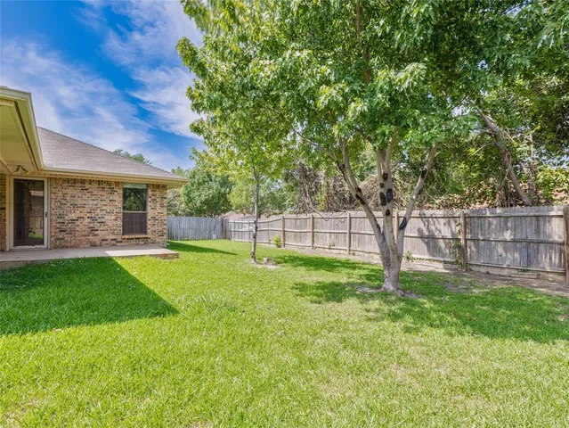 a view of a yard with a house and a large tree