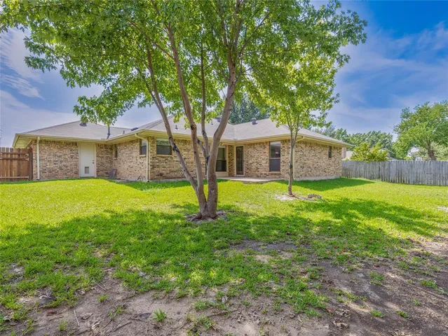 a view of house with a backyard