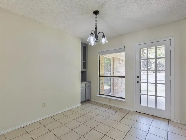 an empty room with windows and chandelier