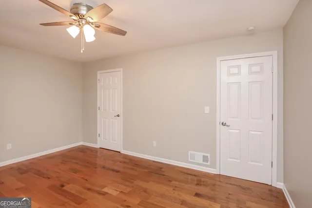 a view of an empty room and chandelier fan
