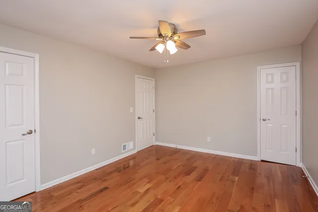 a view of an empty room with wooden floor