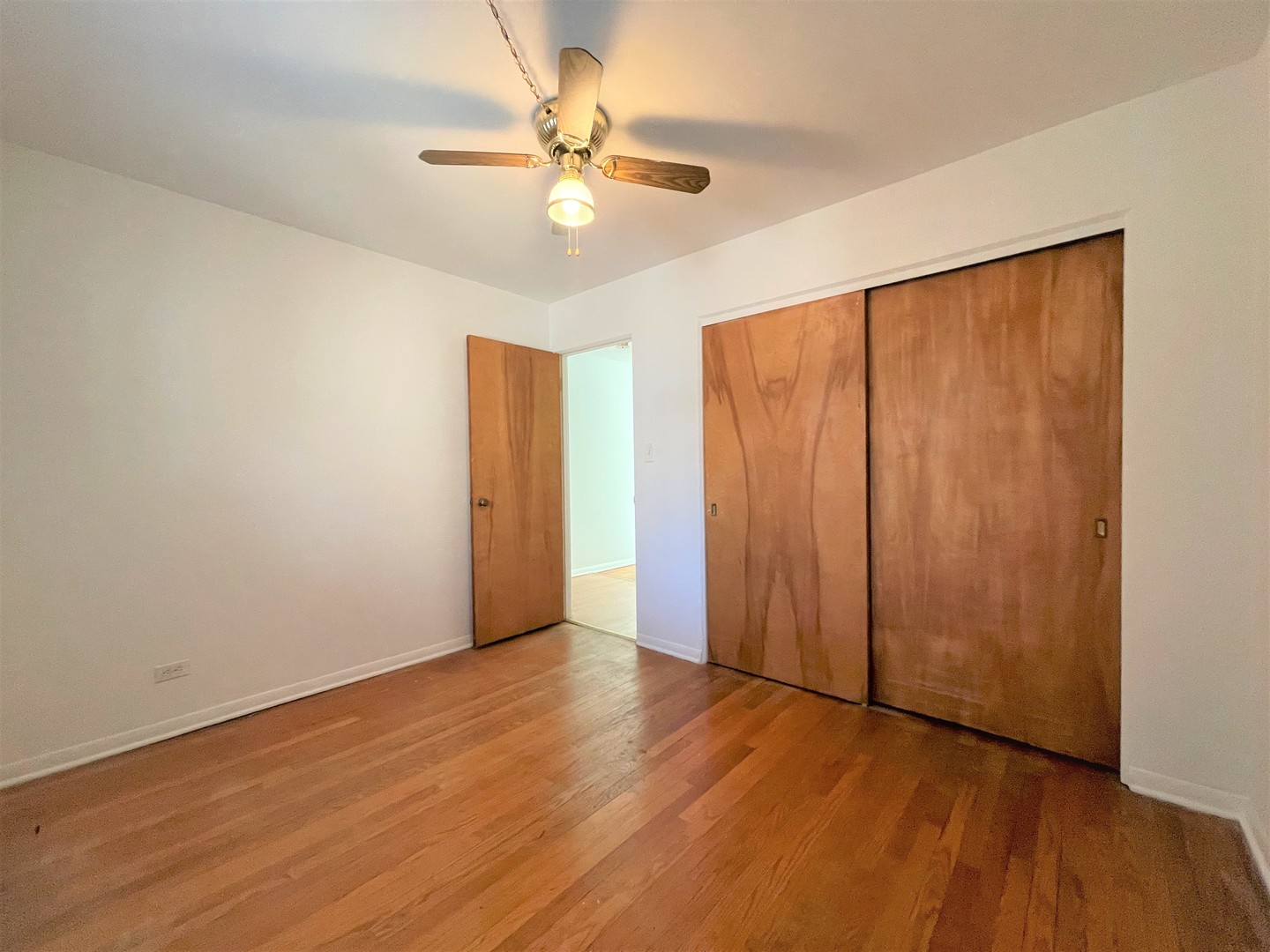 341 Custer Avenue, Unit 2 Evanston, IL 60202 - Photo 12 of 19 an empty room with wooden floor fan and windows