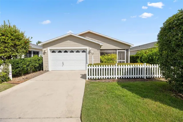 a view of a house with a yard and fence