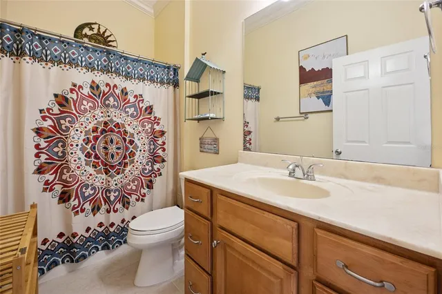 a bathroom with a granite countertop sink mirror vanity and toilet