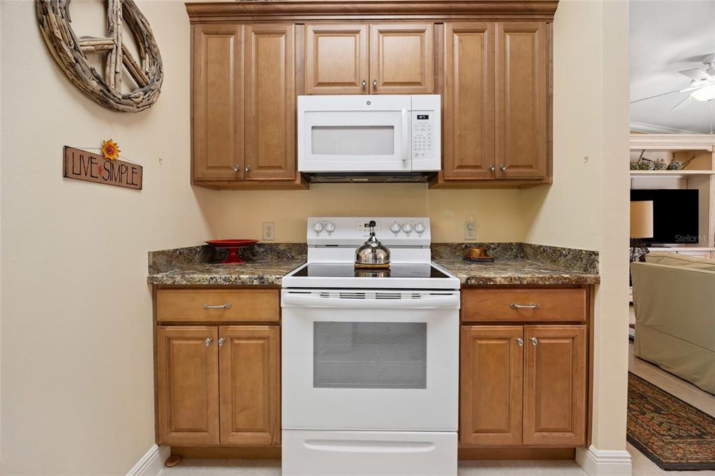 2372 Travis Place The Villages, FL 32162 - Photo 8 of 33 a kitchen with stainless steel appliances granite countertop a stove and a microwave